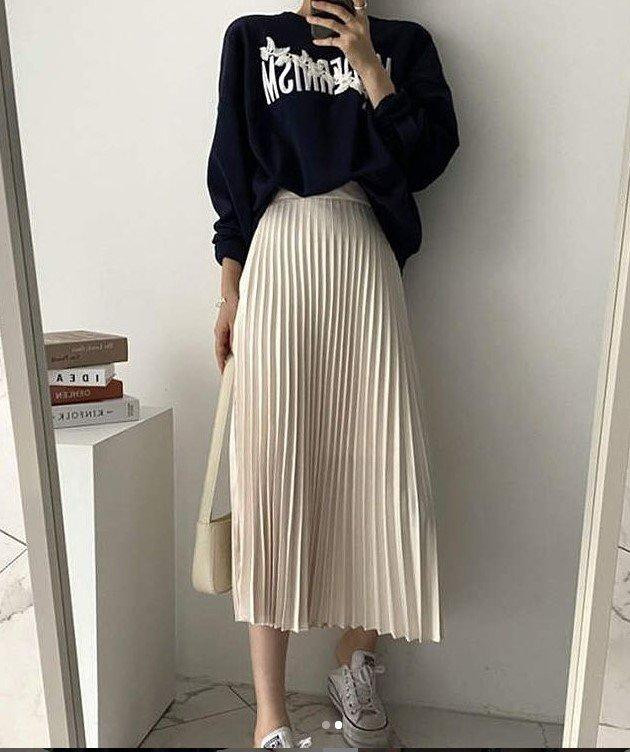 Váy xếp li đi kèm với áo sweater và giày trắng